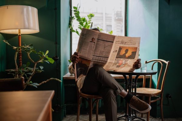 A man sits in a cozy café corner, enjoying a newspaper and relaxed ambiance. — Das geheimnisvolle Bonusprogramm von Alles Spi