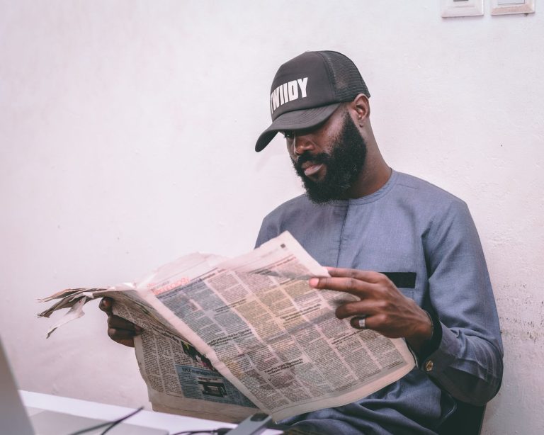 Adult man reading a newspaper indoors, wearing a cap and traditional attire. — Ein umfassender Guide zu den Zahlungsmethoden