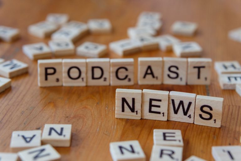 Wooden letter tiles spelling out 'PODCAST NEWS' on a wooden surface. — Pourquoi Chicken Road Casino est-il un choix populaire