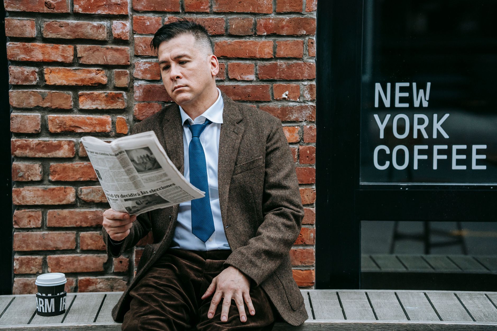 A professional man in formal wear reads a newspaper beside a coffee shop window. — VIP Casino: Ein unvergessliches Spielerleb